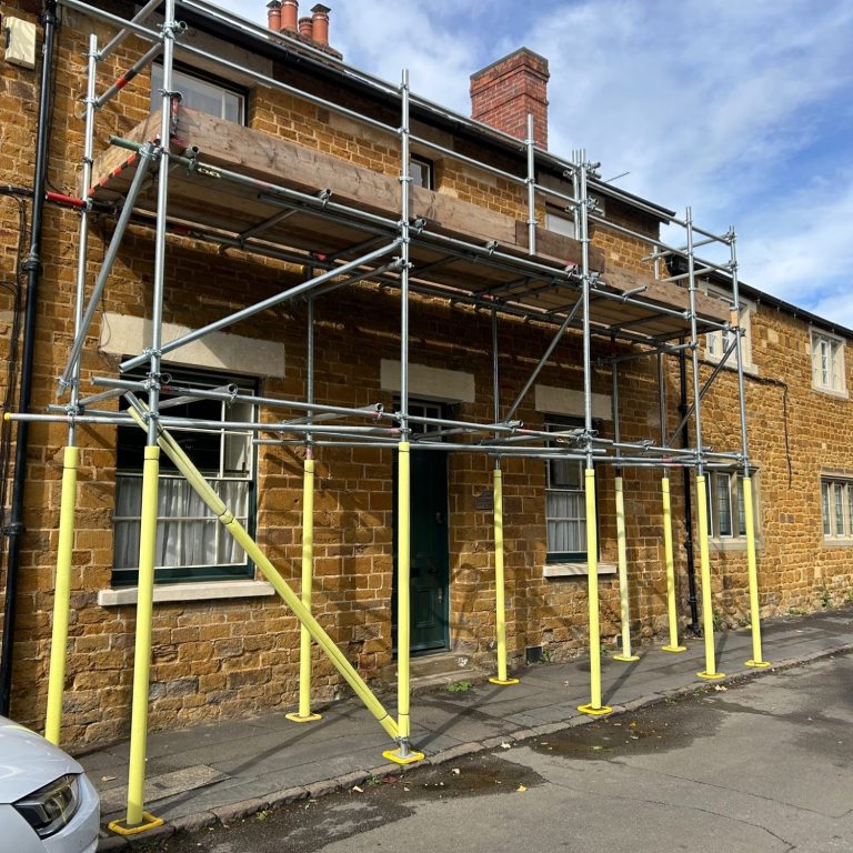 External decorating scaffolding Scaffolding surrounds a two-storey brick building under renovation.